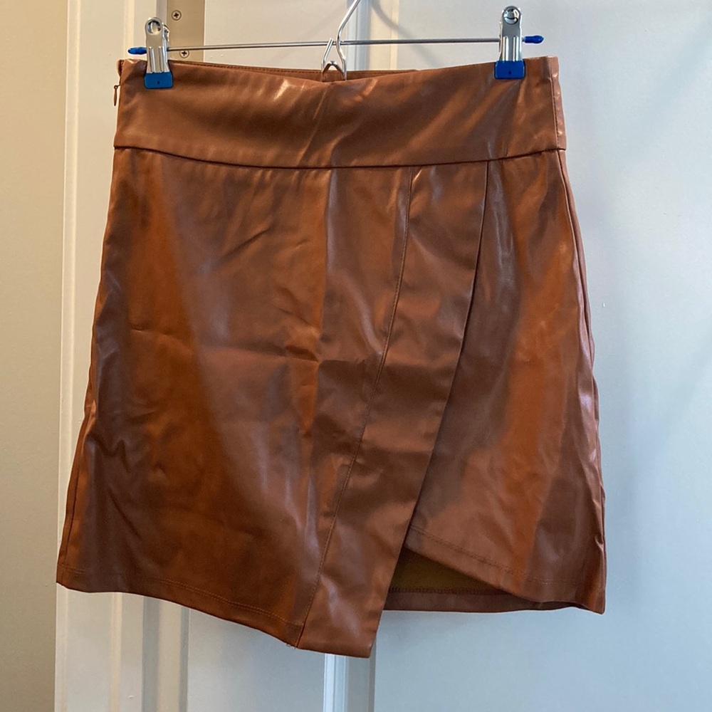Side zip, pleather skirt. New without tags, never worn. Fits a size 4-6 well.